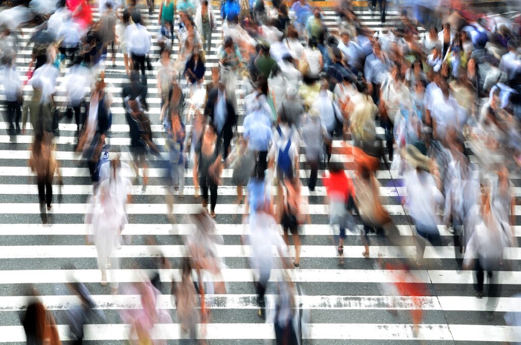 A crowd of blurred poeple walking up a broad flight of stairs.